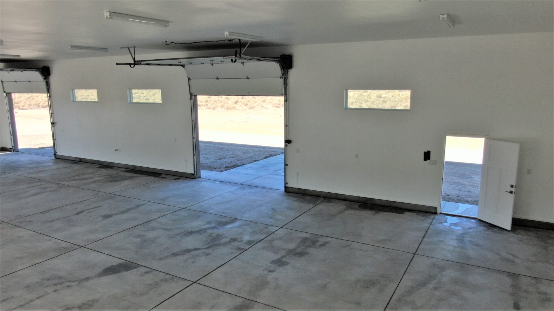 An empty space with garage doors and normals door
